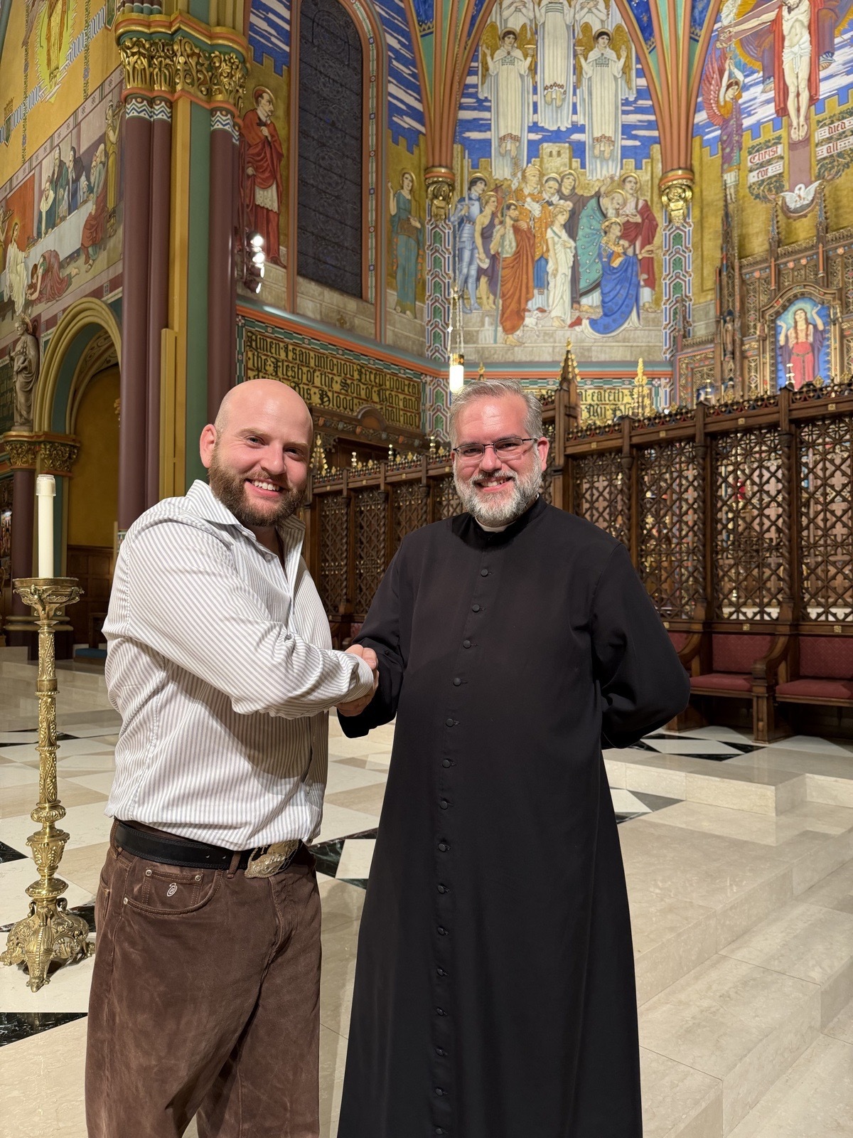 Zak Kline, founder of Hit Em Up, shaking hands with Father Christopher Gray, rector of the Cathedral of the Madeleine, inside the cathedral